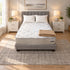 Three Quarter Breeze Cool Max 10" Medium Firm Tight top mattress on a gray upholstered bed with two white pillows and a tan knit throw, in a bedroom with white nightstands, table lamps and a framed landscape print
